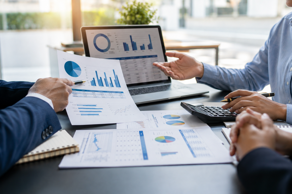 Profissionais analisando o planejamento financeiro do condomínio com relatórios de receitas, despesas e orçamento.